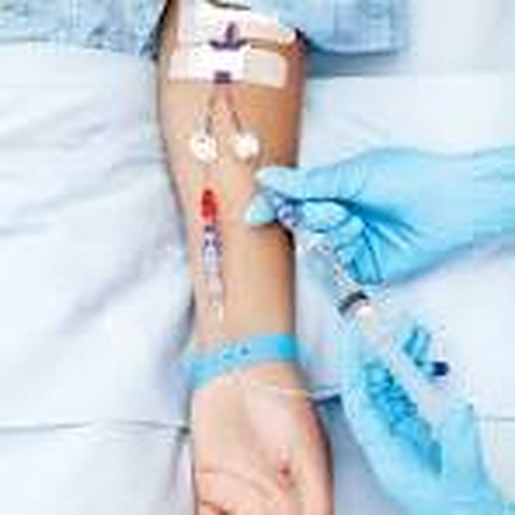 Registered nurse preparing IV therapy equipment at a client's home